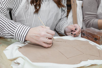 Women's hands knead clay, drawing elements of the product. production of ceramic products