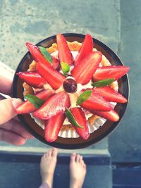 Low section of woman holding fruits on plate
