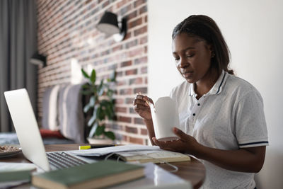 Black woman eating during studies