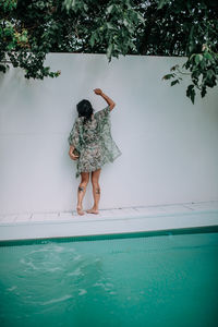 Rear view of woman standing in swimming pool