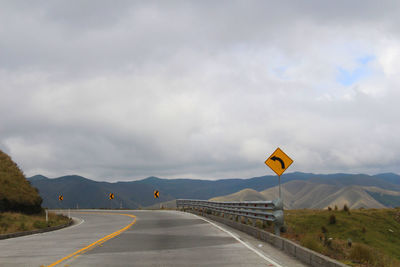 Mountain road against cloudy sky