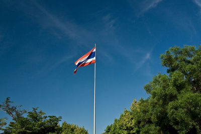 Low angle view of flag against blue sky