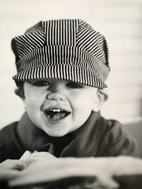 Close-up portrait of cheerful baby boy wearing cap