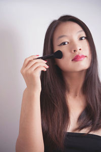 Portrait of a beautiful young woman against gray background