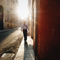 Full length of man walking on street against sky