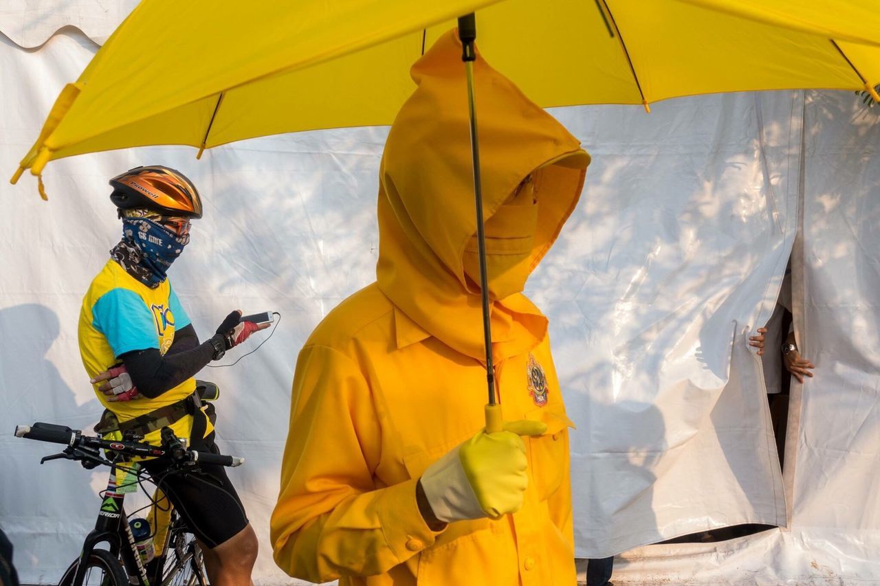 lifestyles, men, leisure activity, yellow, umbrella, adventure, low angle view, casual clothing, person, sky, holding, travel, hanging, fun, day, rear view, multi colored