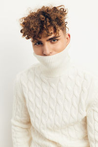 Portrait of young man standing against white background