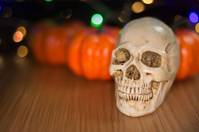 Human skull and pumpkins on table
