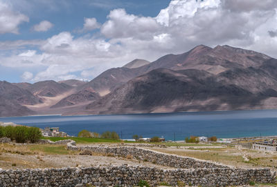 Scenic view of lake by mountains against sky