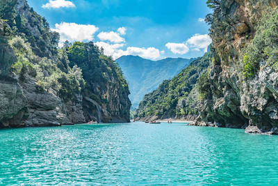 Scenic view of sea and mountains against sky