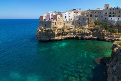 Buildings at sea shore against clear sky