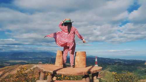 Person standing on mountain against sky