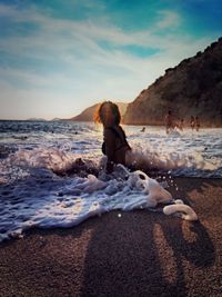 Full length of woman sitting on beach