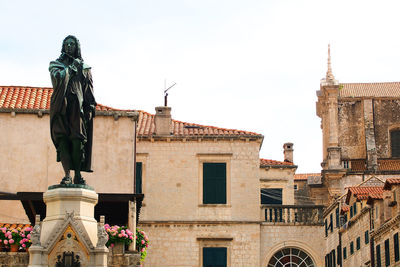 Low angle view of statue against sky in city