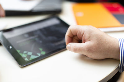 Close-up of man using mobile phone on table