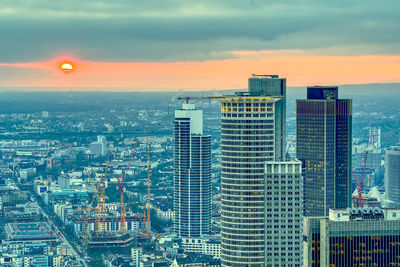 Modern buildings against sky during sunset in city