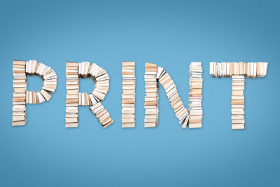 Directly above shot of print text made with books against blue background