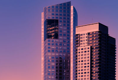 Blue glass windows skyscraper isolated against blue sunset sky.