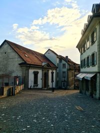 Houses by building against sky