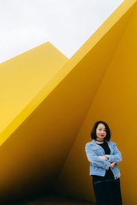 Young woman standing by wall