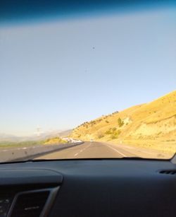 Scenic view of road seen through car windshield