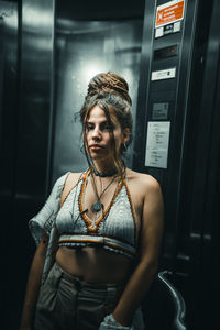 Beautiful young woman standing against wall