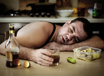 Close-up of man drinking whiskey on table