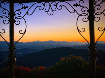 Scenic view of silhouette mountains against orange sky