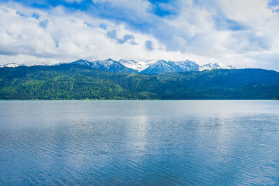 Scenic view of lake by mountains against sky