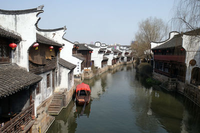 Canal amidst buildings in city against sky