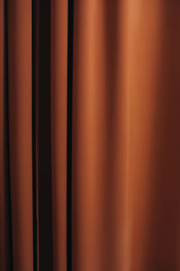 Background texture of orange material curtains. details of a cozy home interior in autumn shades.