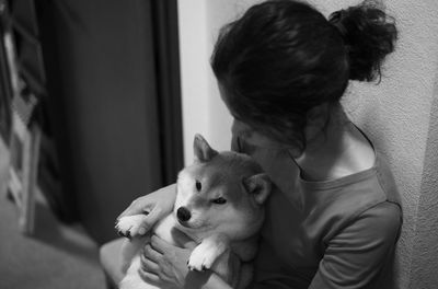 Rear view of woman with dog at home