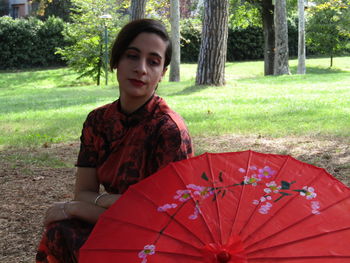 Portrait of smiling young woman sitting on land