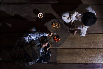 Directly above shot of grandmother cutting fruits with grandson at home