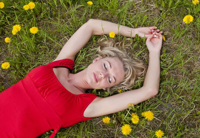 Portrait of woman lying on grassy field