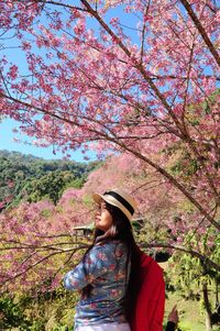 Woman holding cherry tree in park