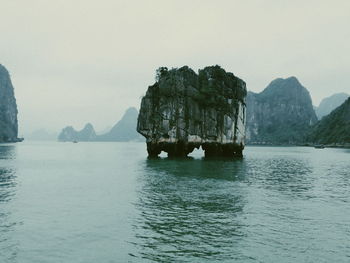 Scenic view of rock formation in sea against clear sky