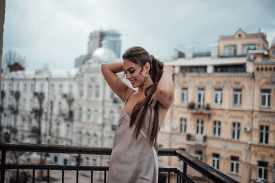 Young woman photographing with city in background