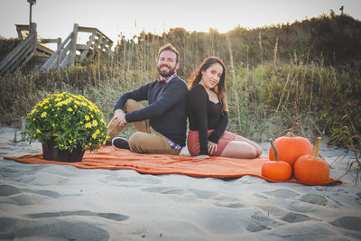 Man and woman on a date on the beach, between sand and sunset