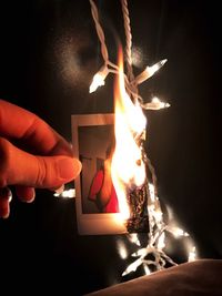 Close-up of hands burning a photograph