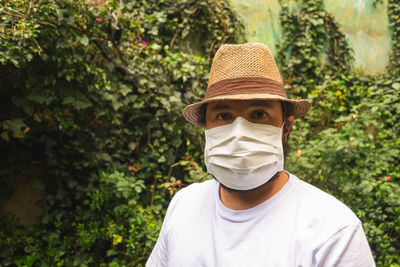 Portrait of man wearing hat against trees