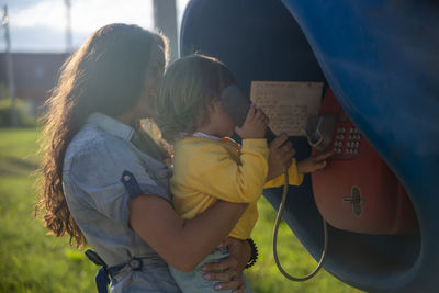 Rear view of mother and daughter while standing outdoors