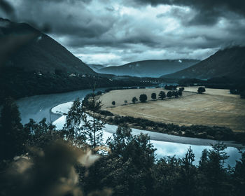 Scenic view of lake by mountains against sky