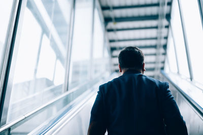 Rear view of man on escalator