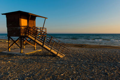 Lifeguard hut on beach against clear sky