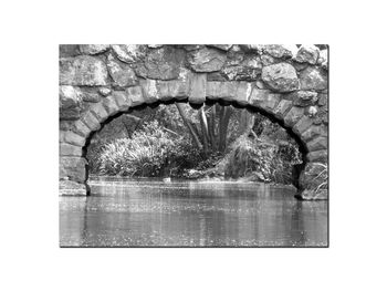 Close-up of stone wall with reflection in water