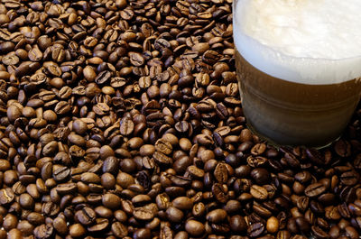 Close-up of roasted coffee beans and cup of coffee