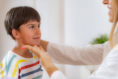 Pediatrician doing development medical exam with boy. checking posture.