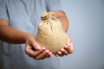 Midsection of man holding jute sack