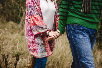 Midsection of friends standing on field